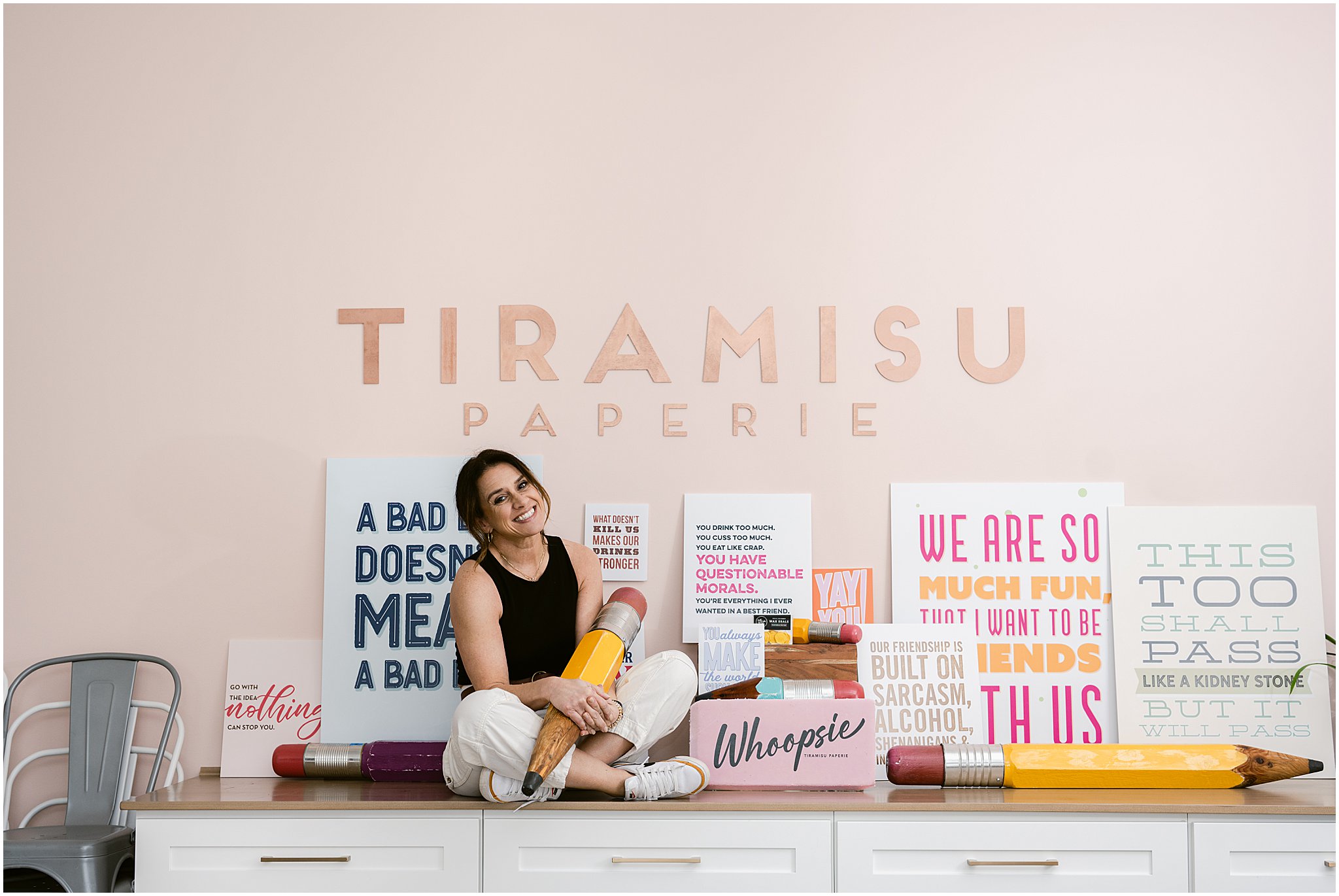 A colorful display featuring a variety of quirky cards and sassy coffee mugs, showcasing Tiramisu Paperie's product range